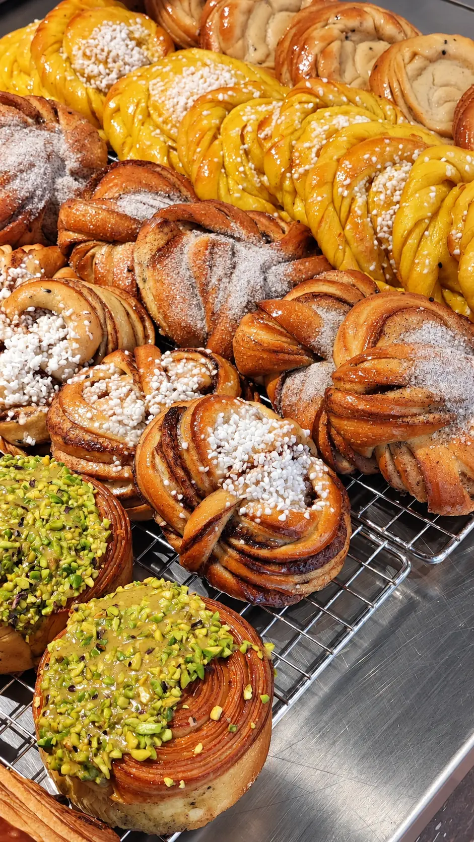 Freshly baked cinnamon, cardamom and pistachio buns cooling on a rack