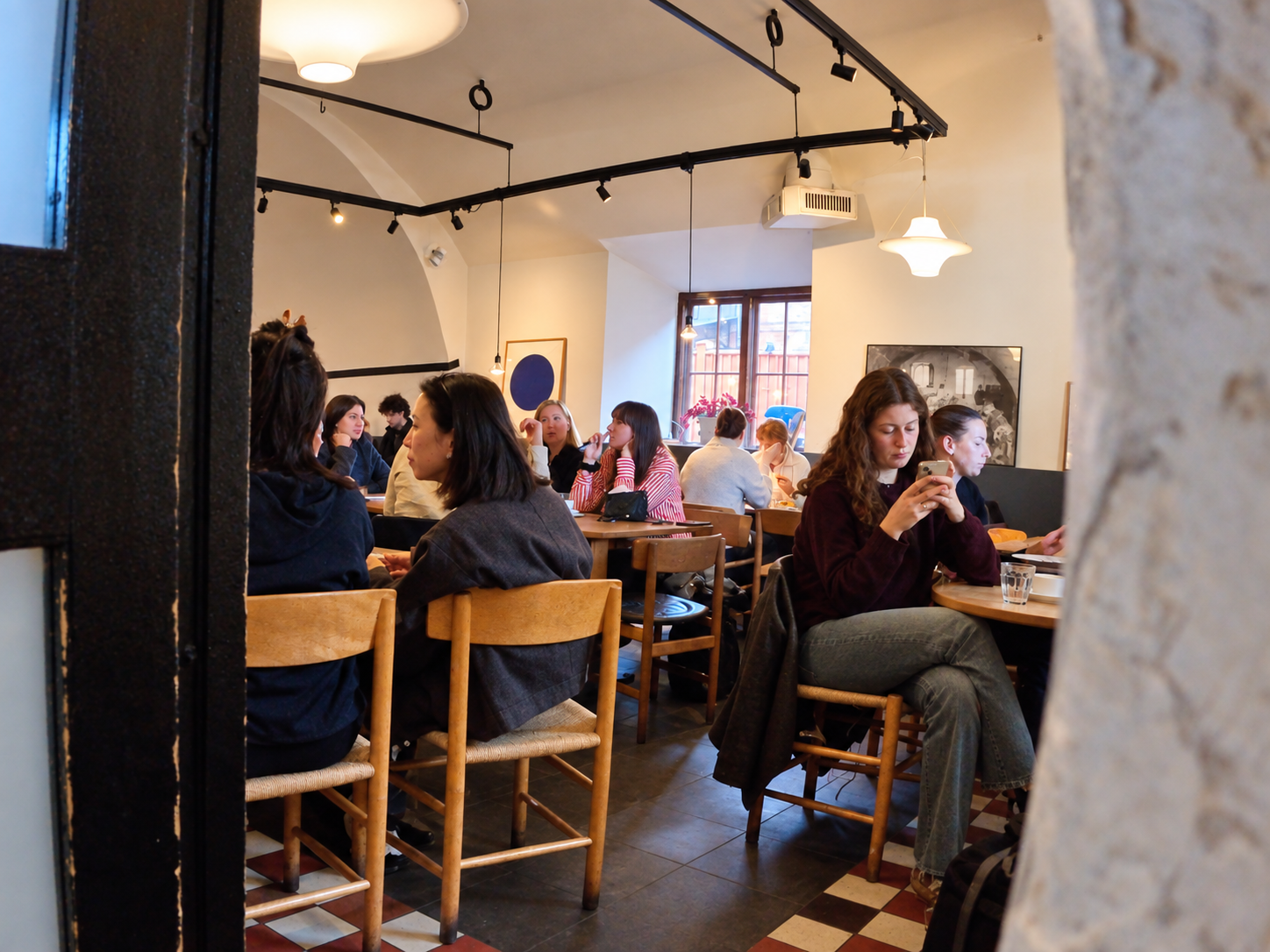Guests at wooden tables under the vaulted arches of Stora Bageriet